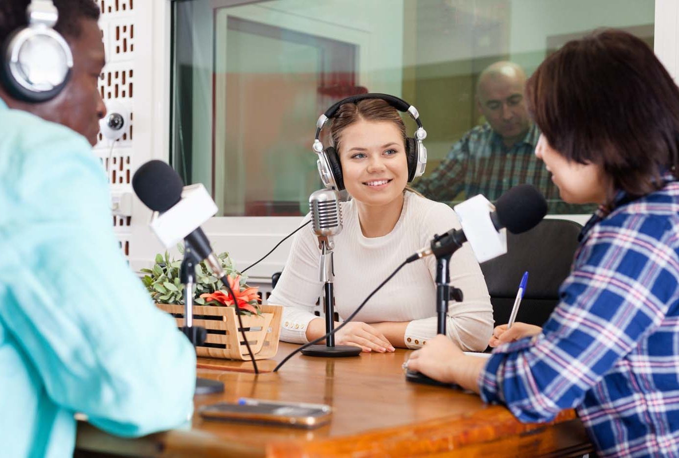 A group of people sitting at a table in a podcast studio.
